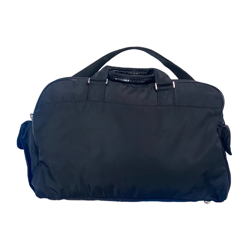 May include: A black nylon travel duffel bag with a single top handle and two side pockets.