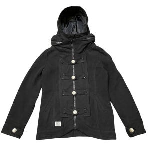 以下が含まれることがあります： 黒色のフード付きジャケット。ジッパー開閉と装飾的なシルバーボタンが特徴です。ジャケットはハイカラーで、下部に小さなラベルが付いています。袖口にはシルバーボタンが付いています。スタイリッシュなアウターウェアです。