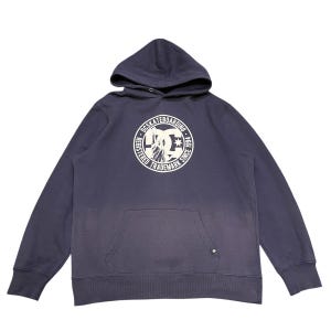 May include: A navy blue hoodie with a front kangaroo pocket and a drawstring hood. The front features a white circular graphic with the text "DC SKATEBOARDING" and a logo. The hoodie is a casual garment.