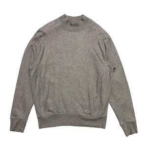 Könnte beinhalten: Ein grauer Langarm-Pullover mit Stehkragen.