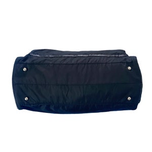 May include: Black quilted nylon tote bag with silver hardware and a zipper closure.