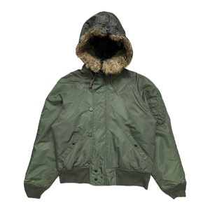 May include: A green hooded bomber jacket with a faux fur lining around the hood.