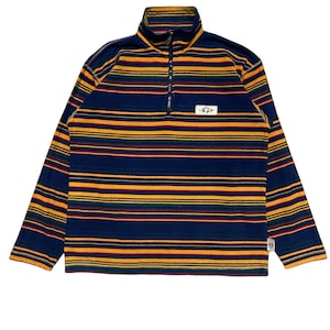May include: A blue and yellow striped long-sleeved shirt with a half-zip closure. The shirt has a small logo patch on the front.