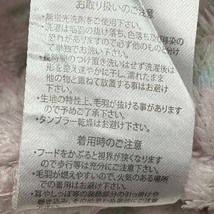 May include: White fabric care label with Japanese text, including instructions for washing, drying, and wearing a hooded garment. The text reads "Care Instructions" and "Wearing Instructions".