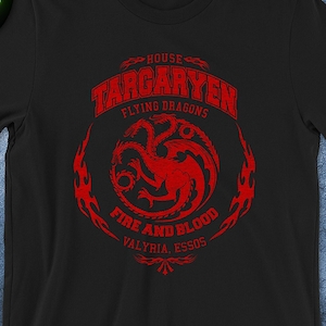 May include: Black t-shirt featuring a red graphic of the Targaryen house sigil with the text "House Targaryen, Flying Dragons, Fire and Blood, Valyria, Essos." Sizes range from S (18" x 28") to 3XL (28" x 33").