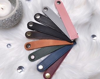 Fastener for bag with button made of genuine leather. Shell Valve for Bag. Detail for clothing bag. Shoulder cap to tie shopping bag, wallet