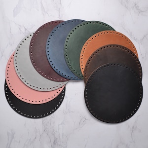 May include: A set of eight round leather circles in various colors, including black, brown, gray, pink, and blue. Each circle has a row of evenly spaced holes around the edge.