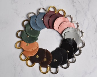 Set of sewn-on fasteners for bag made of genuine leather. Belt clip. Ideas on how to beautifully attach strap to bag sewing taps with D Ring