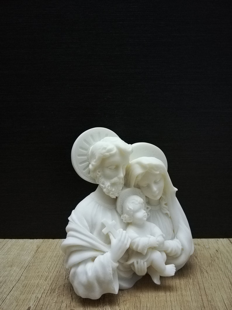 Puede incluir: Escultura de cer&aacute;mica blanca de la Sagrada Familia. La escultura representa a Mar&iacute;a, Jos&eacute; y el ni&ntilde;o Jes&uacute;s. Las figuras est&aacute;n representadas en un abrazo amoroso.