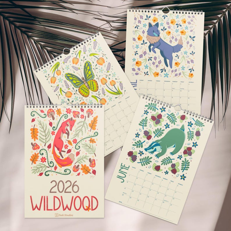 A 2026 wall calendar featuring colourful folk-art animal illustrations displayed in a flat lay. Wire-bound with premium thick paper, this illustrated monthly calendar showcases vibrant artwork for each month. Ideal for shoppers looking for a 2026 calendar, animal art calendar, home décor calendar, or unique artist-designed wall calendar.