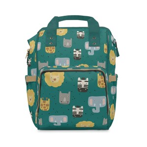 Puede incluir: Una mochila azul verdosa con cierre de cremallera y correas ajustables. La mochila presenta un patrón repetido de varios animales, incluidos leones, cebras, elefantes, jirafas y rinocerontes.
