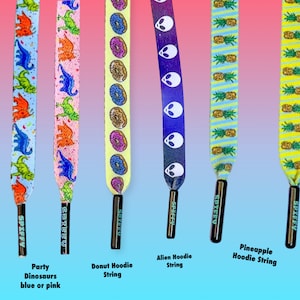 Puede incluir: Cinco diseños diferentes de cordones con una variedad de patrones, incluyendo dinosaurios, donas, extraterrestres, piñas y una sudadera con capucha de dona. Los cordones son todos negros con un logotipo "SPIFFY" blanco.