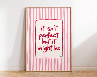 Può includere: Stampa incorniciata con sfondo a righe rosa e bianche. L'opera presenta il testo rosso "it isn't perfect but it might be" all'interno di un bordo rosso. La cornice è color legno chiaro.