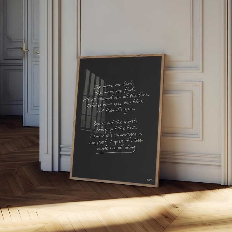 K&ouml;nnte beinhalten: Ein gerahmter schwarzer Druck mit wei&szlig;em handschriftlichem Text. Der Text lautet: "The more you look, the more you find. It's all around you all the time. Catches your eye, you blink and then it's gone." Der Druck ist in einem hellen Holzrahmen.