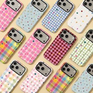 May include: A selection of patterned phone cases. Designs include gingham, plaid, and star patterns in pink, blue, green, and yellow. Each case has a black border and a camera cutout. The cases are arranged in a grid.