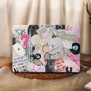 Puede incluir: Un portátil con un collage colorido de pegatinas e imágenes. Las pegatinas incluyen una pantera negra, un corazón, un 7, un 8, un 2, una copa de martini, un libro, una cámara, una concha, una nota de agradecimiento, un disco, un lazo y una cita que dice "No estás bendecido con tu vida, cámbiala."