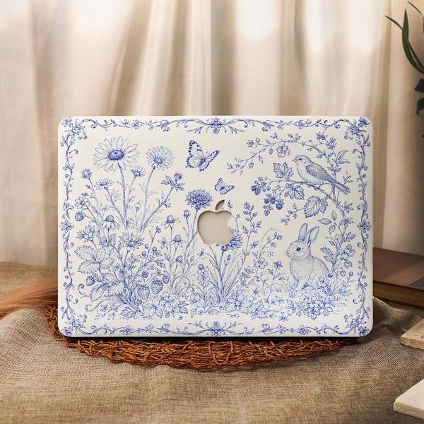 May include: A white laptop hard shell case featuring a blue botanical toile-style print. The design includes detailed illustrations of daisies, strawberries, butterflies, a small bird perched on a branch, and a rabbit, with a central Apple logo cutout.