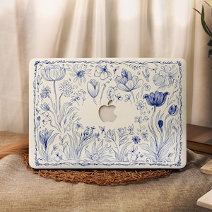 May include: A white laptop case featuring a blue floral design. The design incorporates a variety of flowers and leaves, including tulips, lilies, and ferns. The case has a white border with a blue outline.