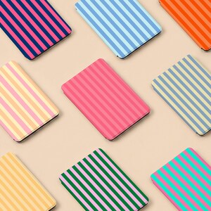 Könnte beinhalten: Eine Sammlung rechteckiger Hüllen mit vertikalen Streifen in verschiedenen Farben, darunter Rosa, Blau, Grün und Orange. Die Hüllen sind auf einem neutralen Hintergrund angeordnet und zeigen eine Vielzahl von Designs.