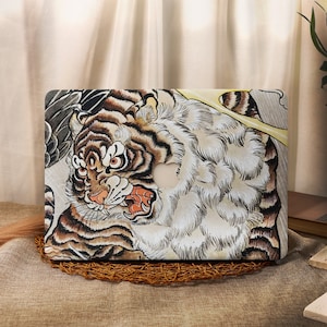 Peut inclure: Une peau d'ordinateur portable avec une illustration détaillée d'un tigre à l'expression féroce. Le tigre est représenté dans des tons de brun, noir et blanc, sur un fond jaune. La peau est conçue pour s'adapter à un ordinateur portable, avec une découpe pour le logo Apple.