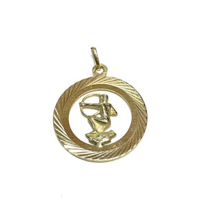 Op de afbeelding: Gouden hanger met een gedetailleerde afbeelding van het sterrenbeeld Boogschutter, een centaur met een boog en pijl, in een rond frame met een textuur.