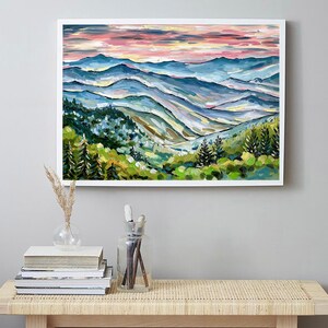 May include: A painting of a mountain landscape with a pink and blue sky. The mountains are painted in shades of blue, green, and yellow. There are trees in the foreground and a valley in the distance.
