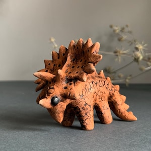Handmade clay ceramic Triceratops dinosaur in brown clay for a gift