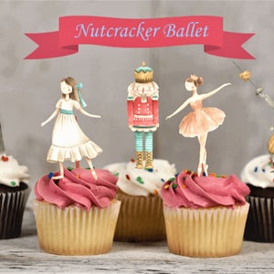 May include: Five cupcakes decorated with Nutcracker Ballet themed toppers. The toppers are of a ballerina, a nutcracker, a mouse king, and a girl in a white dress. The cupcakes are frosted with pink and white frosting and have colorful sprinkles.