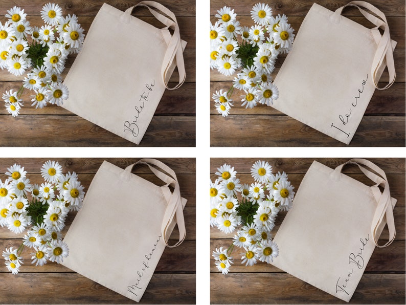 May include: Four canvas tote bags with long handles, each with a different script text: "Bride to be", "I do crew", "Maid of honor", and "Team Bride". The bags are beige and are arranged on a wooden surface with a heart-shaped arrangement of white daisies.