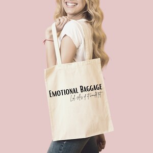 May include: A white canvas tote bag with black text that reads "Emotional Baggage Lol. As if it would fit."