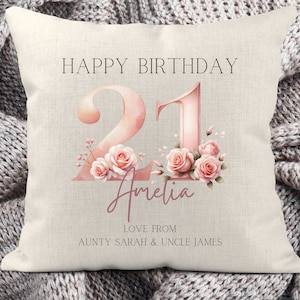May include: A white pillow with the text "Happy Birthday 21 Amelia Love From Aunty Sarah & Uncle James" in black and pink. The number 21 is in pink with watercolor-style flowers.