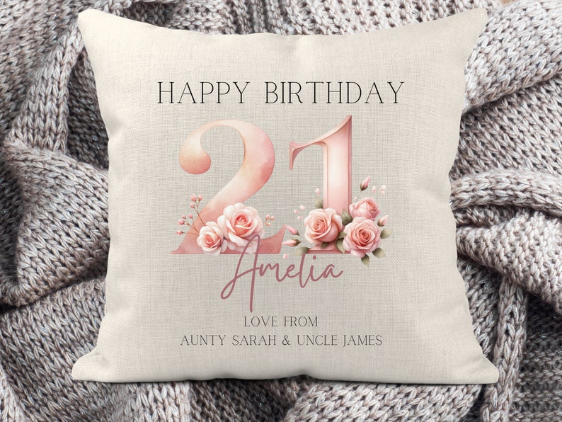 May include: A white pillow with the text "Happy Birthday 21 Amelia Love From Aunty Sarah & Uncle James" in black and pink. The number 21 is in pink with watercolor-style flowers.