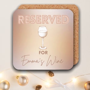 May include: A pink and orange gradient coaster with the text "RESERVED FOR Emma's Wine" and a drawing of a wine glass.