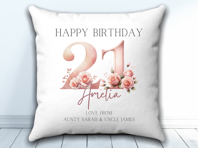 May include: White pillow with pink floral design and the text "Happy Birthday 21 Amelia Love from Aunty Sarah & Uncle James"