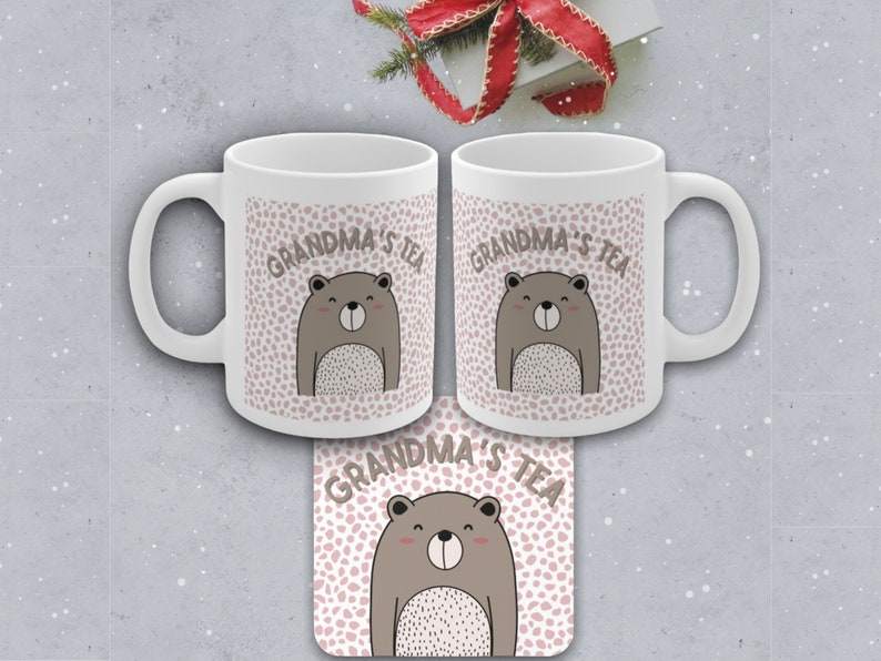 May include: Two white ceramic mugs with a brown bear and pink polka dot design. The text "Grandma's Tea" is printed on the mugs. A matching coaster with the same design is also shown.