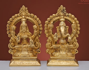 Peut inclure: Deux statues en métal doré de divinités hindoues, Lakshmi et Ganesha, assises sur des socles ornés. Les statues sont sur un fond brun.
