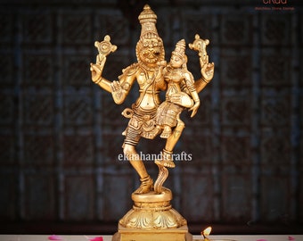May include: A gold-coloured metal statue of a Hindu deity, Shiva, dancing with his consort Parvati. The statue is intricately detailed and features a base with a floral design.