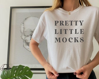Könnte beinhalten: Weißes T-Shirt mit dem Aufdruck "PRETTY LITTLE MOCKS" in Schwarz.