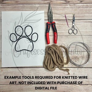 May include: A set of tools and materials for creating wire knit art. The tools include a pair of pliers, a pair of scissors, and a spool of twine. The materials include a metal wire circle and a printed template of a paw print.