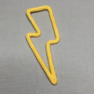 May include: A yellow knitted lightning bolt shape.
