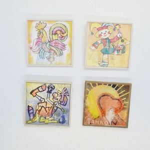 May include: Four vintage framed illustrations with colorful cartoon characters. The top left frame features a rooster with a red, yellow, and pink design. The top right frame features a jester with a red, yellow, and blue design. The bottom left frame features a cartoon character with a yellow, blue, and purple design. The bottom right frame features a sun with a red heart and the word "ДАНКО" in gold lettering.