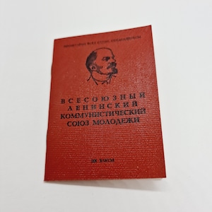 May include: A red booklet with the text "Всесоюзный Ленинский Коммунистический Союз Молодежи" (All-Union Leninist Communist Youth Union) and a portrait of Vladimir Lenin.