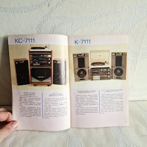 Könnte beinhalten: Ein Vintage-Broschüren-Doppelseite mit einem KC-7111-Radiokomponenten-System. Die Seite zeigt zwei verschiedene Setups mit Lautsprechern, Plattenspielern und Steuereinheiten. Der Text enthält die Worte "VERSATILE RADIO COMPONENT SYSTEM".