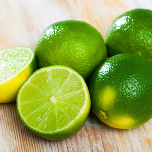 A close up of fresh and juicy key limes on a wooden table