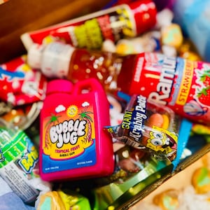close up of retro candy snacks and gummies and snacks. retro sours, slime lickers, SpongeBob krabby patty, baby bottle bop,