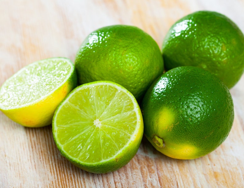 A close up of fresh and juicy key limes on a wooden table