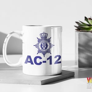 Op de afbeelding: Witte keramische mok met een blauw politiebadge en de tekst "AC-12" erop gedrukt.