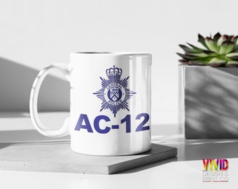 May include: White ceramic mug with a blue police badge and the text "AC-12" printed on it.