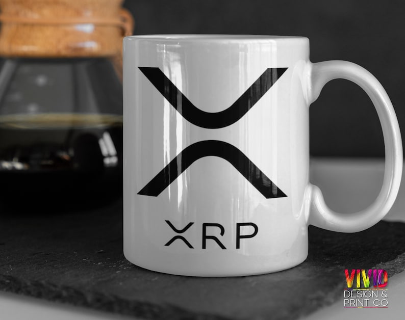 White ceramic mug featuring the bold XRP (Ripple) logo in black. Perfect for cryptocurrency investors, blockchain traders, and fintech enthusiasts.
