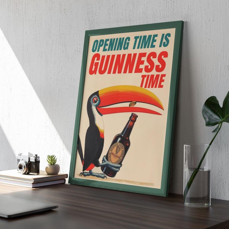 Puede incluir: Un anuncio vintage enmarcado con un tuc&aacute;n sosteniendo una botella de Guinness. El p&oacute;ster tiene un marco verde y el texto "OPENING TIME IS GUINNESS TIME" en rojo y azul. El tuc&aacute;n tiene un gran pico amarillo, rojo y negro.